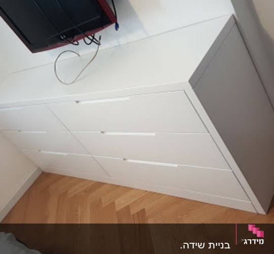 שידה לבנה עם שישה מגירות בחדר שינה